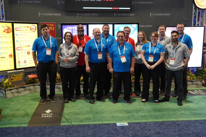 The Howard Company team in branded blue polos at the NRA 2026 booth in Chicago, alternate group photo