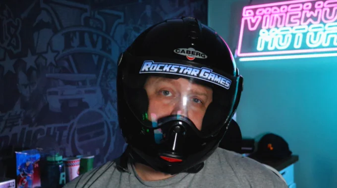 Vinewood Motors wearing a helmet with the Rockstar Games Midnight Club sticker.