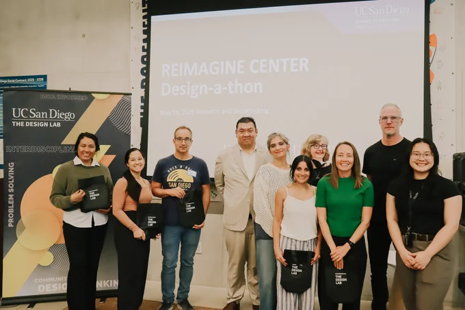 Group standing in front of REIMAGINE Center Design-a-Thon PowerPoint