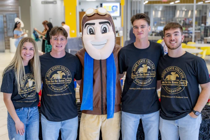 Four RSC students smile for a photo with Rowdy the Raider.
