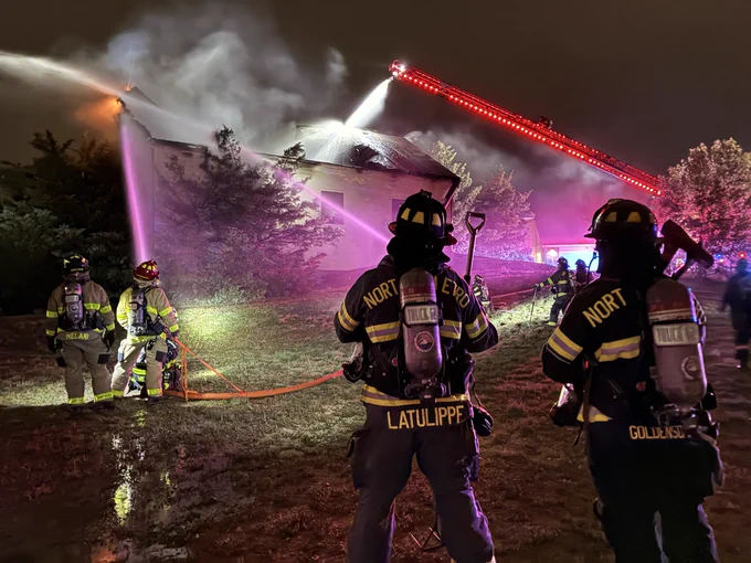 Nighttime image of firefighters extinguishing a fire