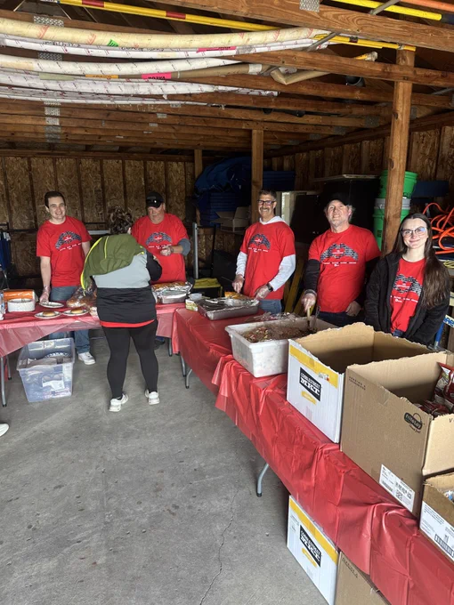 Group of volunteers smile while passing out food.