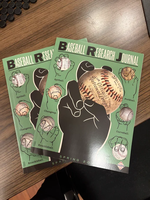 Two copies of a publication with a green and black illustration on the cover demonstrating different pitching grips