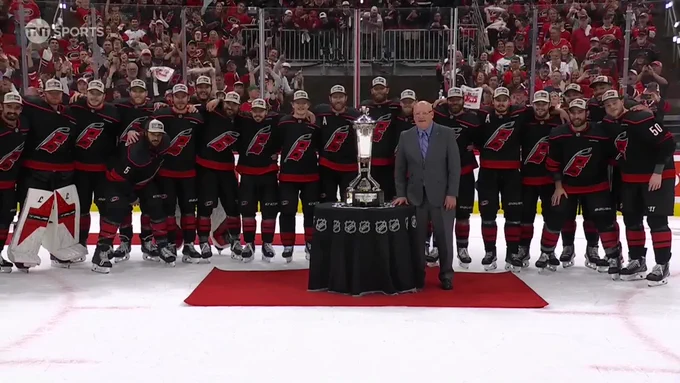 Canes players pose around the trophy.