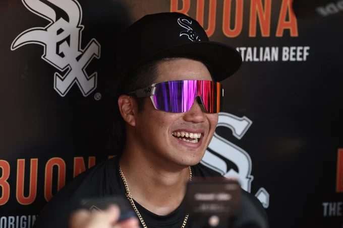 Rikuu Nishida smiles while wearing a black Chicago White Sox hat and purple and red-tinted sunglasses.