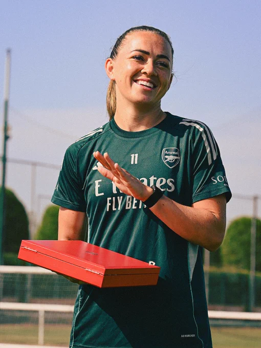Katie McCabe smiling whilst receiving a farewell gift.
