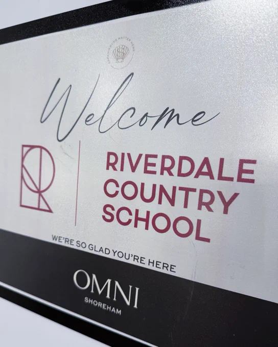 A sign reads, "Welcome Riverdale Country School." 