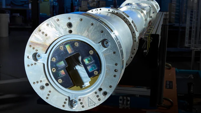 Viewing the flexible imaging diffraction diagnostic for laser experiments (FIDDLE) from this angle highlights five hybrid complementary metal-oxide-semiconductor (hCMOS) sensors (rectangular objects near the center) that record x-ray diffraction patterns from compression experiments at the National Ignition Facility (NIF). The Livermore team custom-designed FIDDLE to house and shield the hCMOS sensors while withstanding the extreme conditions generated by NIF experiments. FIDDLE’s imaging system uses up to eight hCMOS sensors situated approximately 50 millimeters away from the tested material sample, which is held by the self-shielding target. High-energy drive beams (red) compress the material over tens of nanoseconds while backlighter beams (blue) generate a bright flash of x-rays that diffract through the material to produce x-ray diagnostic signals.