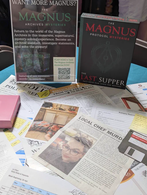 A photograph of The Magnus Protocol Mysteries, with the contents of the box spread out on a table, including newspaper reports, photos and other documents. 