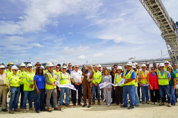 Mayor Jane Castor cuts a ribbon at Cemex at Port Tampa Bay. A large crowd with construction workers and professionals stand together.