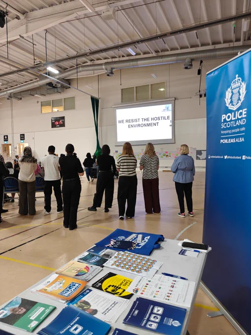Police Scotland event with presentation on resisting hostile environments and crime prevention leaflets on display.