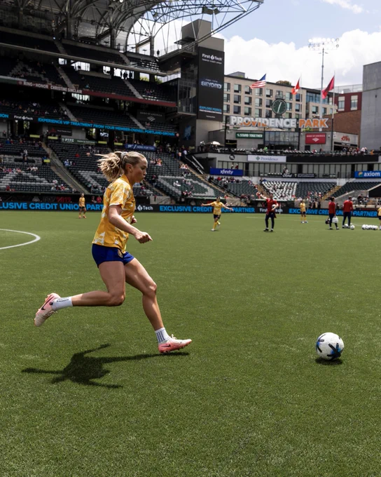 Kate kicking a ball during warmups at PORvUTA