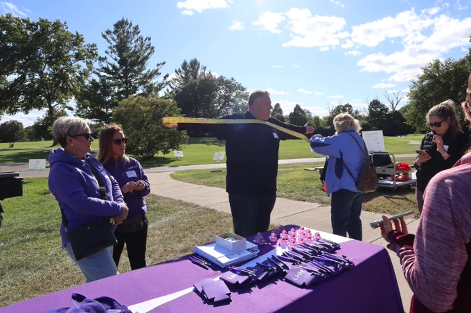 Volunteer measuring a wingspan of raffle tickets beside the LHH booth at last year's Shot in the Dark.