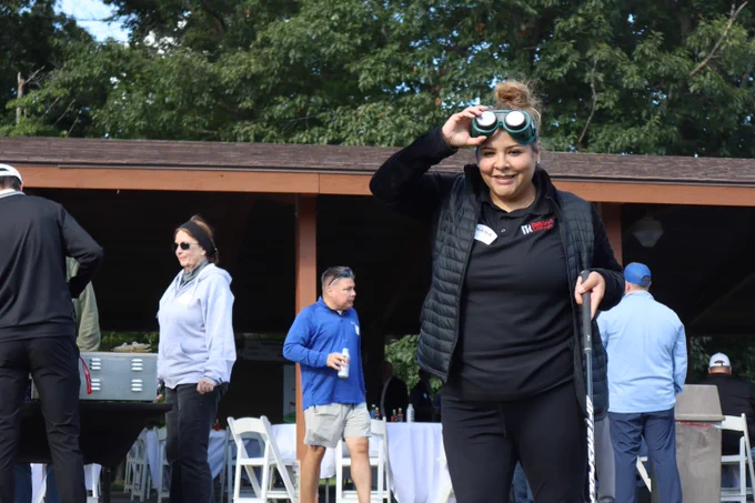 Diana Meza pushing up vision simulator glasses she is wearing after using the putting green.