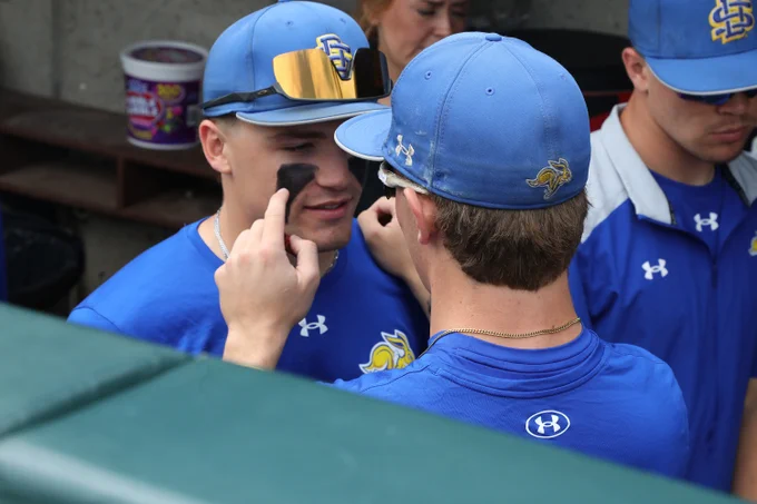 South Dakota State outfielder Carter Taylor (right) applies eye black to the face of shortstop Keagen Jirschele before the  Jackrabbits' NCAA Regional elimination game against Arizona State on May 30, 2026, at Hawks Field in Lincoln, Nebraska.