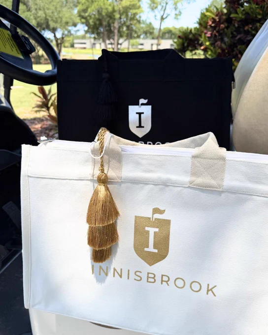 A photo of black and white Innisbrook branded golf cart tote bags on a golf cart at Innisbrook Resort.