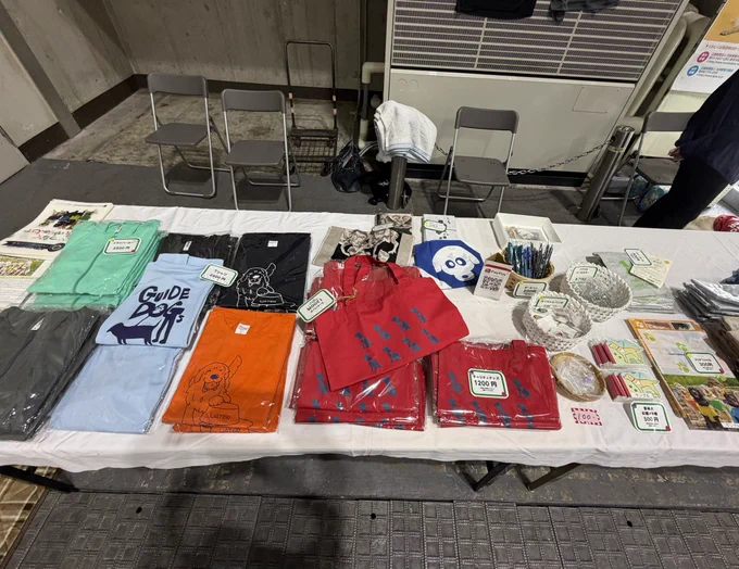 ブースを上から撮影したもの。Tシャツやトートバッグなどのチャリティグッズが並んでいる。