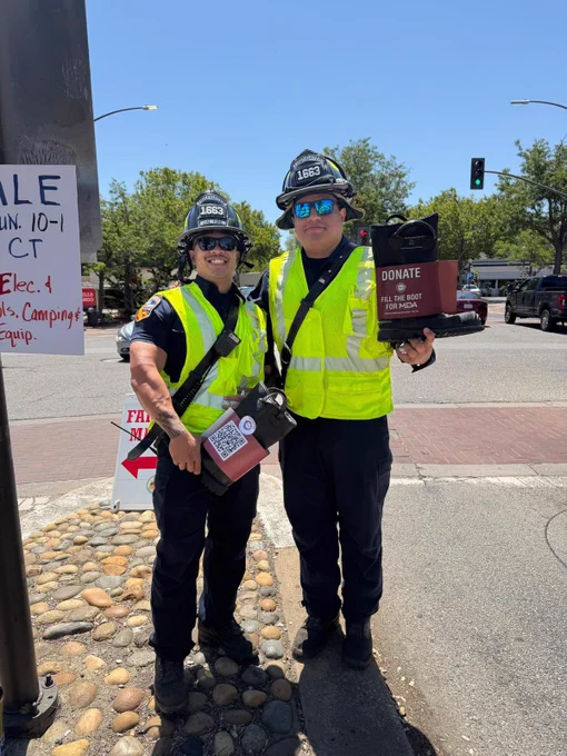 Two CAL FIRE Firefighters holding boots for fundraiser.