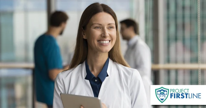 A smiling healthcare worker is holding a clip board. Two coworkers stand in the background. Project Firstline logo is visible at bottom.
