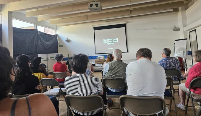Community sitting down ready to watch a projected screen 
