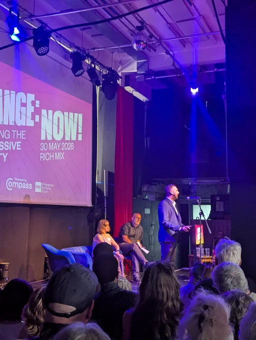 Zack speaking on a stage at Compass