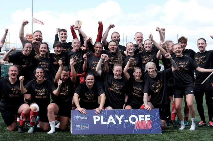 The team poses in front of a board that reads 'play-off winners'