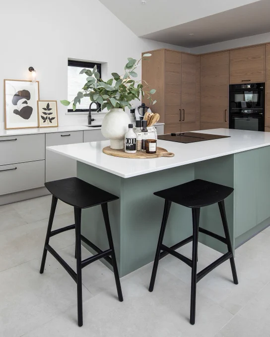 scandi-style kitchen with tall oak cabinets and a warm green kitchen island 