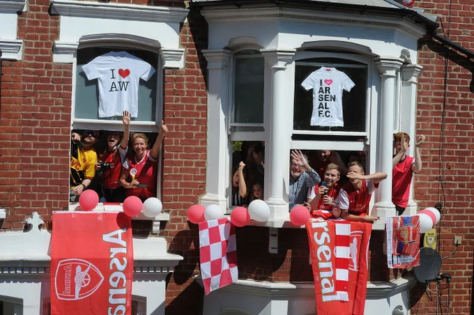 Arsenal supporters celebrate from the windows of their homes in London.