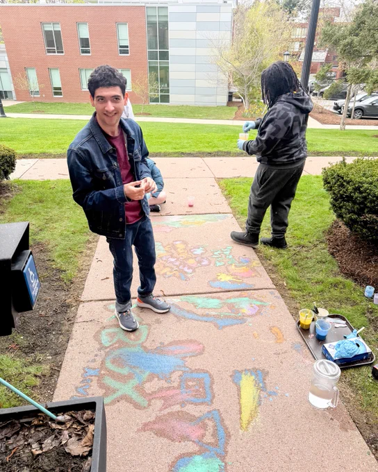 Xavier smiles after painting with sidewalk chalk