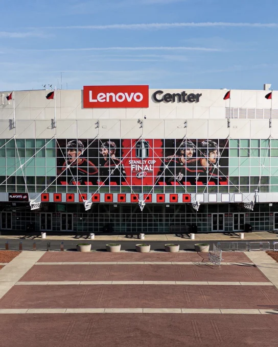 A photo outside the Lenovo Center with a Stanley Cup Final banner above the warning flags