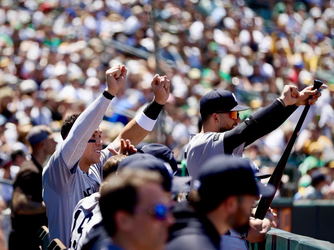 Aaron Judge and J.C. Escarra celebrate in the dugout.