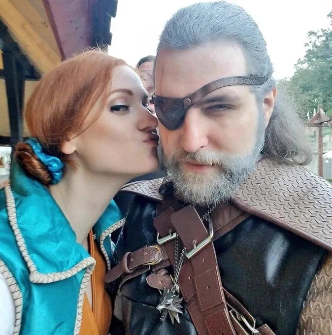 The Opera Geek dressed as Triss from Witcher 3 kisses her husband Pirate JEsus who is dressed as Geralt
