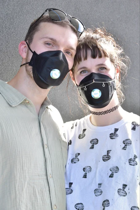 Both Britt and Brian are wearing black BNX N95 respirators installed with sip valves. They posed for Julie Lam who writes for MaskTogetherAmerica at the @PositiveDevianceNYC Vinyl Music party where everyone is required to wear a respirator while having a fun time.