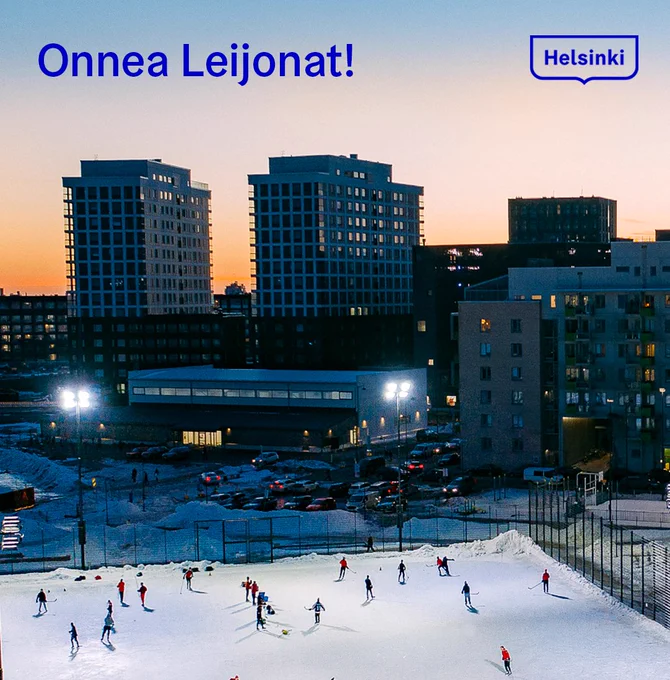 Etualalla luistelijoita jäällä, taka-alalla kerrostaloja.