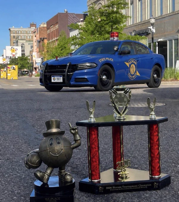 Michigan State Police Patrol Vehicle with the Gus Macker 1st Place trophy, and the 2026 Hero’s Tournament Champion Trophy.