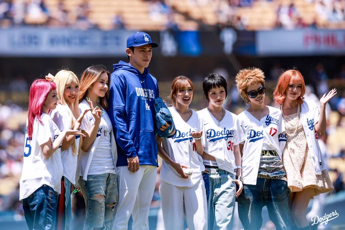 A photo of Roki Sasaki posing for a photo with members of XG.