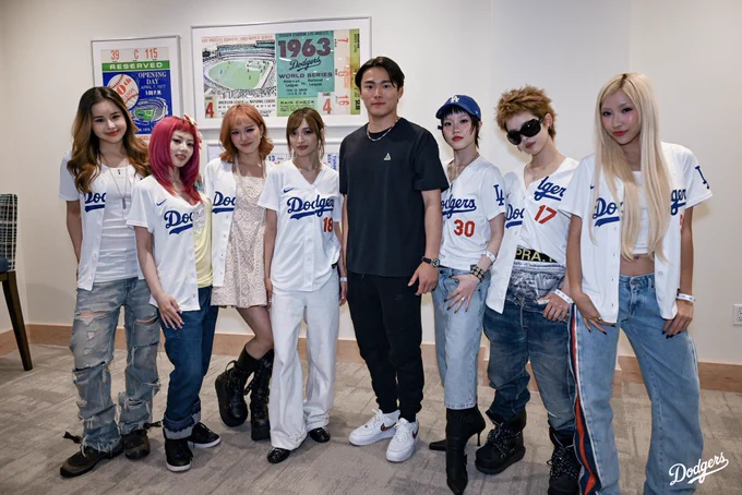 A photo of Yoshinobu Yamamoto posing for a photo with members of XG.