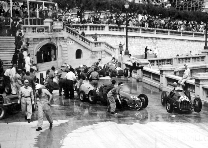 Chaos at Tabac with crashed cars, drivers and marshals littering and partially blocking the track, the road surface wet with seawater. On the right of frame, Alberto Ascari threads through the scene in his Ferrari. 1950 Monaco Grand Prix.