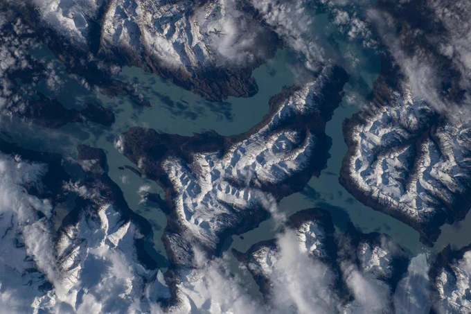Una vista captada desde la órbita terrestre baja el 6 de mayo de 2026 del lago Argentino, en Argentina, rodeado de montañas cubiertas de nieve blanca. El agua del lago tiene un distintivo color azul. Se observan nubes blancas sobre algunas de las cumbres. 