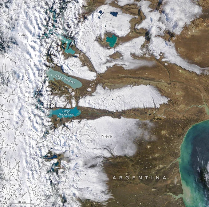 Vista satelital del sur de Argentina y parte de la Patagonia, donde extensas franjas de nieve cubren las llanuras altas al este de los Andes. En esta imagen, adquirida el 3 de abril de 2026, Se observan los lagos Viedma y Argentino en tonos azul turquesa, nubes sobre la cordillera y la costa atlántica a la derecha de la imagen. 
