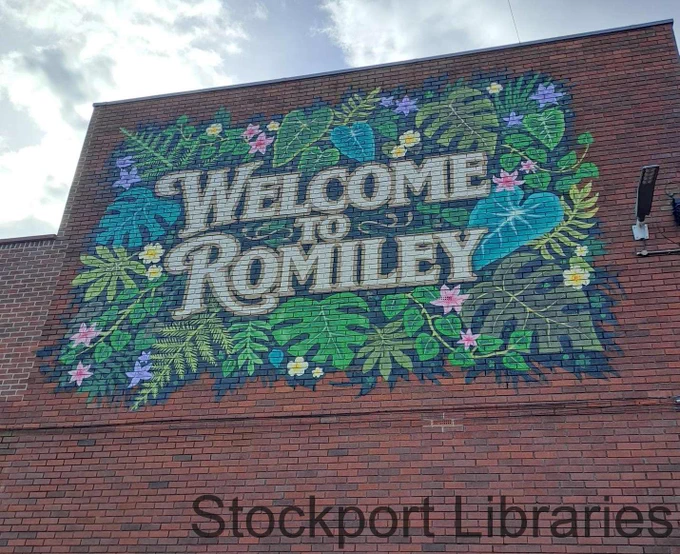 Mural welcoming visitors to Romiley, featuring 'WELCOME TO ROMILEY' text surrounded by tropical leaves and flowers.