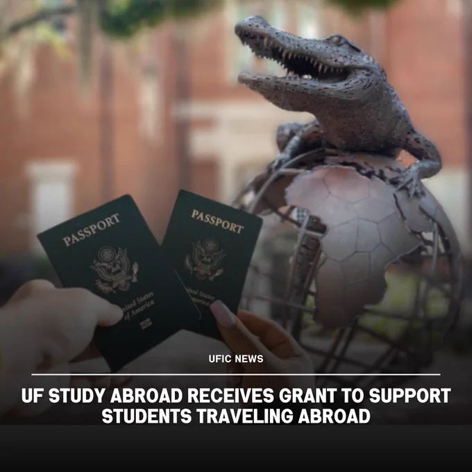 Two hands holding U.S. passports near a bronze alligator sculpture perched on a globe outdoors.