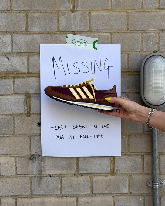An image of a person's hand holding a brown adidas SL 72 OG trainer in front of a white piece of paper with text saying "Missing - last seen in the pub at half-time".