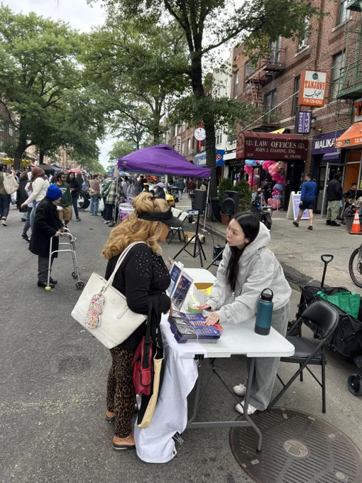 Asian American Federation staff speaking with a community member at Malikah's Eid festival.
