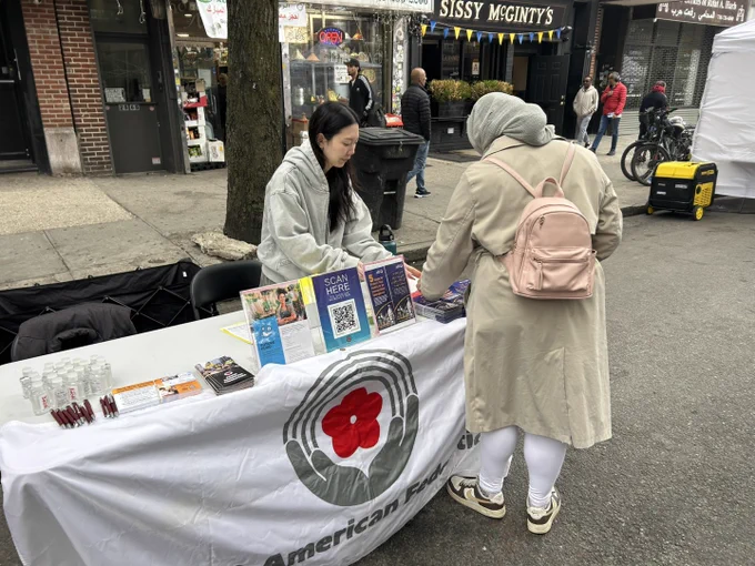 Asian American Federation staff speaking with a community member at Malikah's Eid festival.