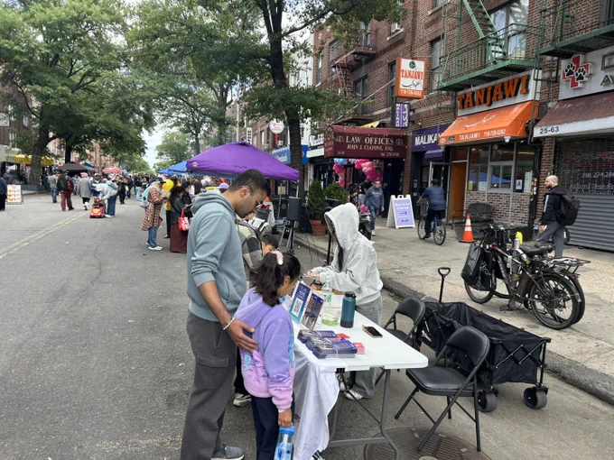 A family stops by the Asian American Federation table at Malikah's Eid festival.