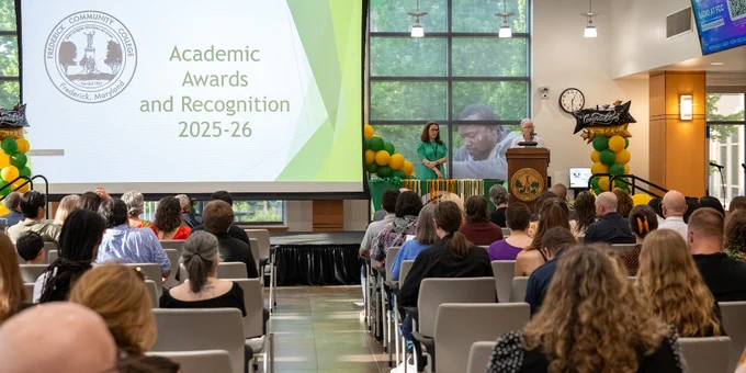 Audience seated in the FCC Student Center watching a presentation on Academic Awards and Recognition for 2025-26 on a large screen.