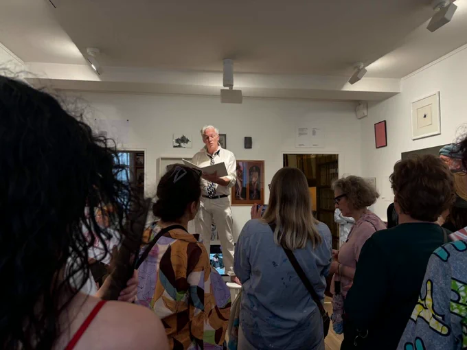 A crowd listening to poet Jason Stoneking perform his text at the Galerie Arnaud Lefebvre in Paris