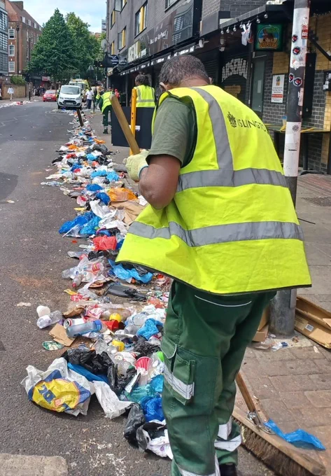 Street cleaning officers sweeping the streets, rubbish lines the streets