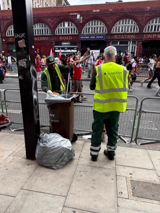 Street cleaning officers clearing litter, Holloway tube in the background